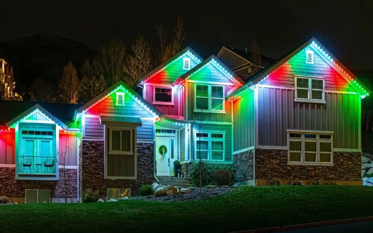 The same home shown lit at night and in daylight, with the Trimlight channel blending into the roofline