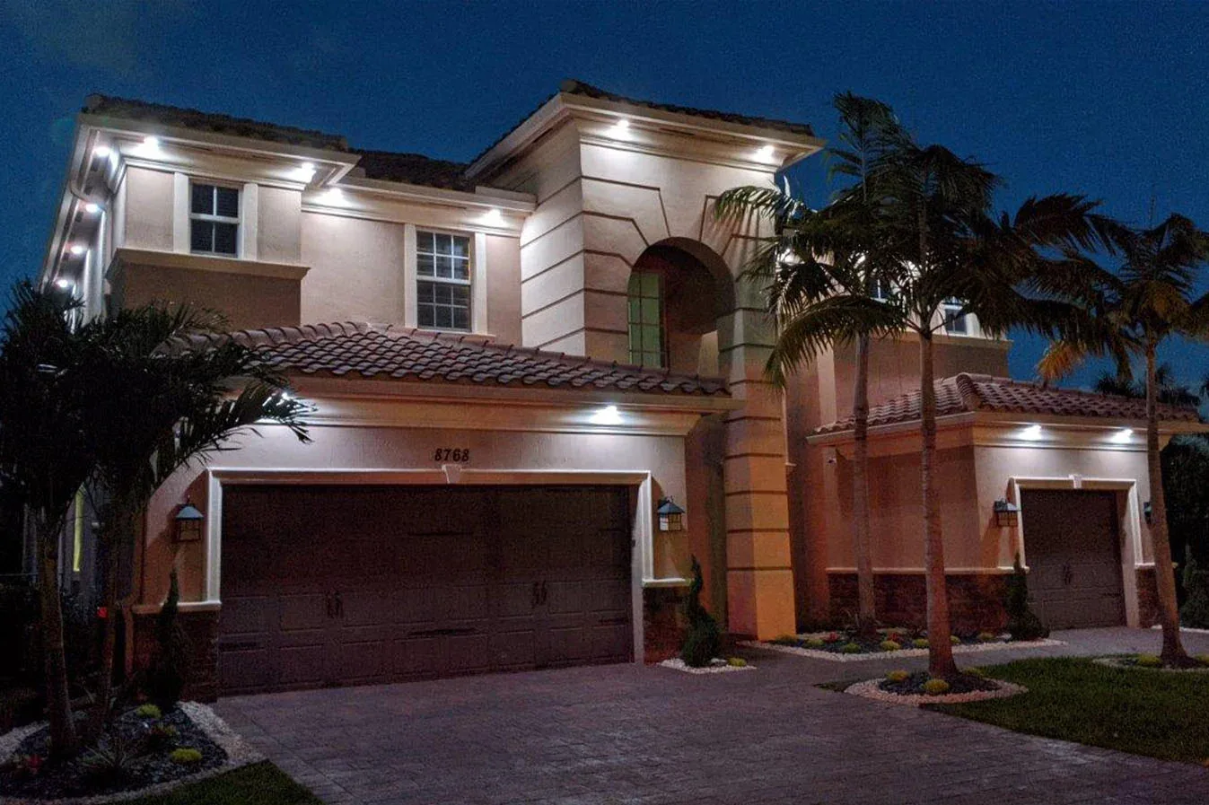 Warm white Trimlight downlighting on a two-story home at night